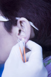 Close-up of doctor examining patient ear in hospital