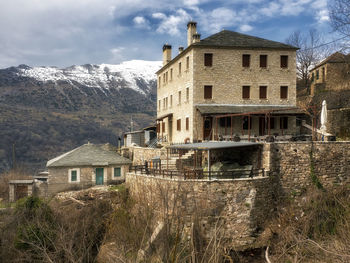 House by buildings against sky