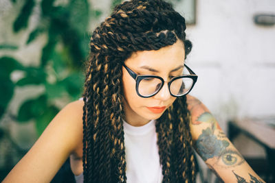 Young woman looking down while wearing eyeglasses