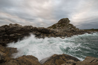 Scenic view of rocks in sea against sky