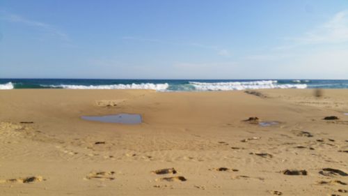 Scenic view of beach against blue sky