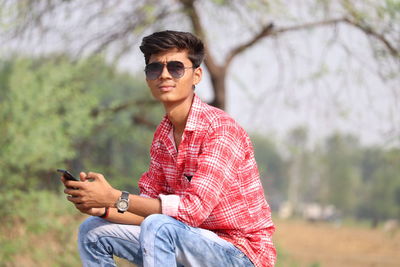 Young man using mobile phone outdoors
