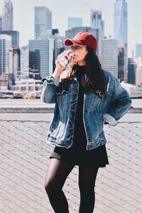 Full length of young woman standing in city