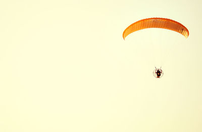 Low angle view of parachuting against clear sky