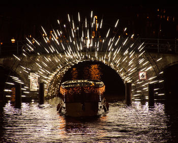 Illuminated ferris wheel in city at night