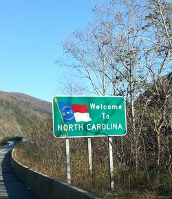 Road sign against clear blue sky