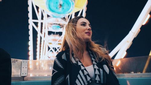 Portrait of young woman in city at night