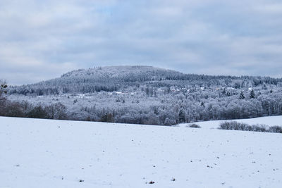 Snow covered landscape against sky