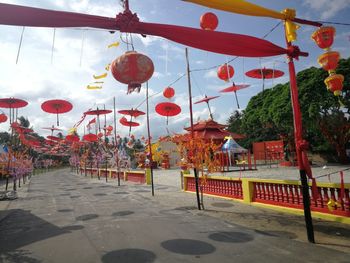 Red lanterns hanging on street against sky