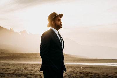 Man standing on beach against sky