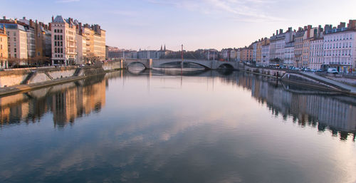 The quays of saône in lyon with its old buildings reflecting in the water with the morning light