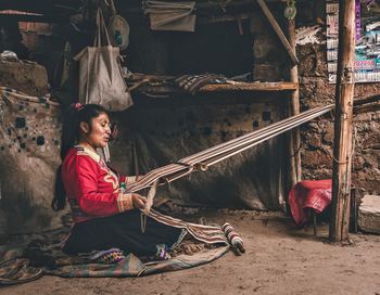 Side view of a girl standing against the wall
