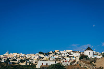 Buildings in town against blue sky