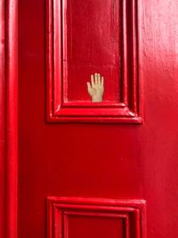 Close-up of mailbox on red door