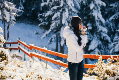 Woman standing on snow covered mountain