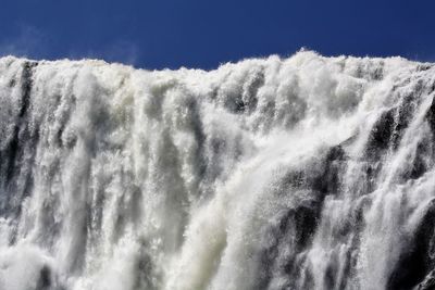 Low angle view of waterfall against sky