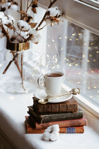 High angle view of coffee with books on window sill