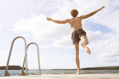 Full length rear view of man diving into lake