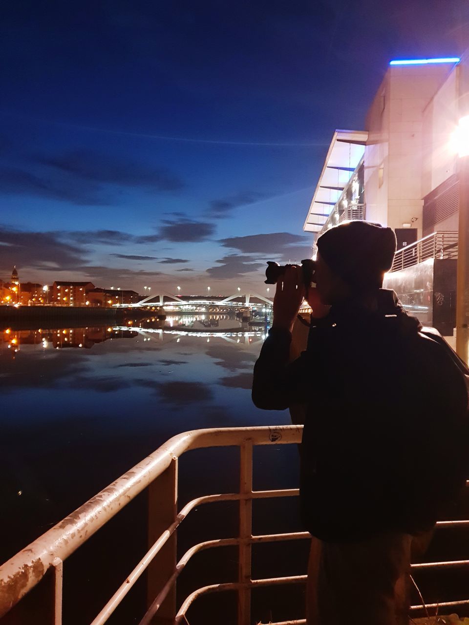 MAN PHOTOGRAPHING AT ILLUMINATED CAMERA