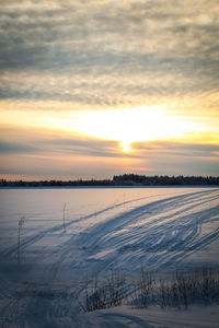 Scenic view of snow field against sky during sunset