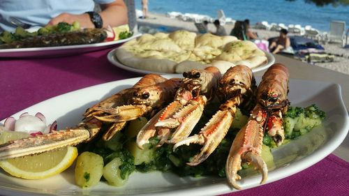 Close-up of fresh grilled scampi in plate with lemon slice in restaurant