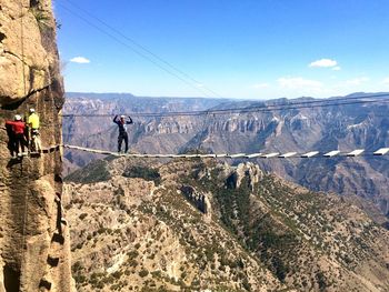 Man standing on cliff against mountains