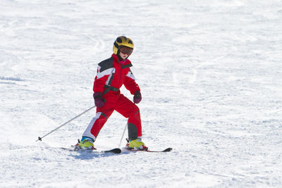 Teenage girl skiing on snow covered land