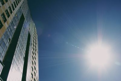 Low angle view of sun shining through clouds