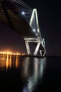 Low angle view of bridge over river against sky at night