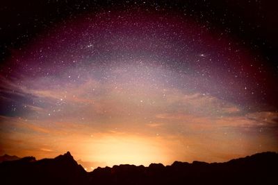 Scenic view of silhouette mountains against sky at night
