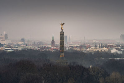 Statue of liberty in city against sky