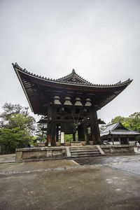 Temple by building against sky