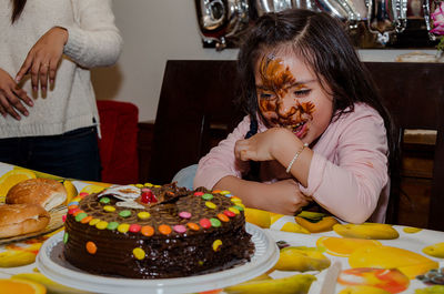 Smiling girl with cake on face during birthday party