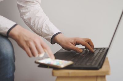 Midsection of man using mobile phone