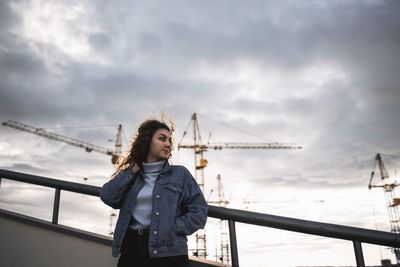 Woman standing on bridge against sky