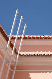 Low angle view of roof and building against clear blue sky