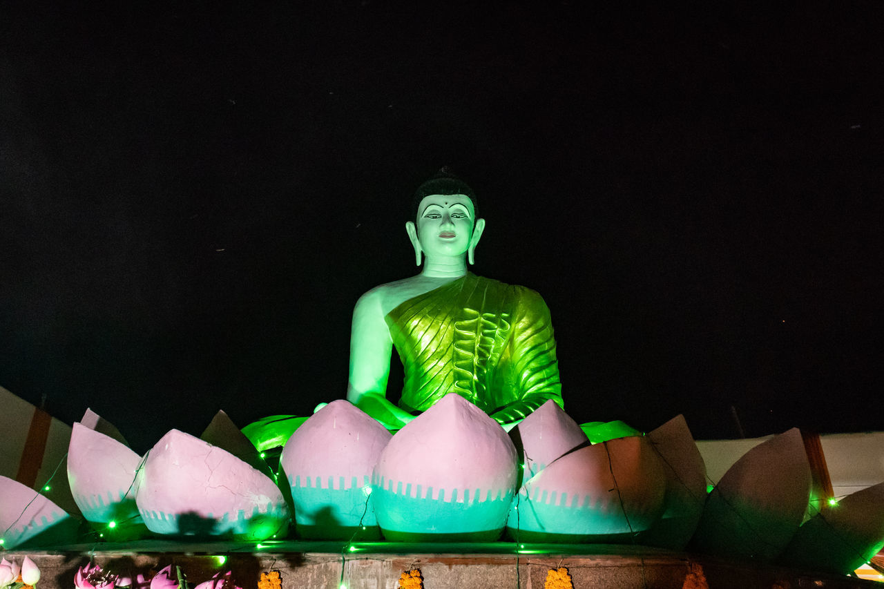 SCULPTURE OF ILLUMINATED STATUE AGAINST SKY