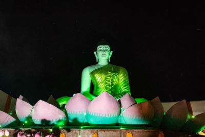 Sculpture of illuminated statue against sky at night
