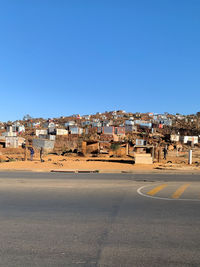 Buildings in city against clear blue sky