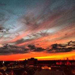 Illuminated buildings against sky during sunset