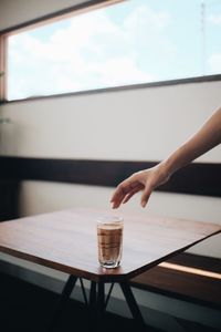 Hand holding coffee cup on table