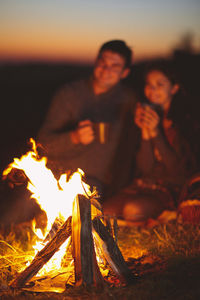 Low angle view of people relaxing on log