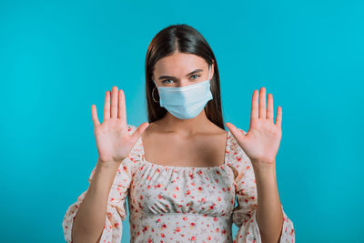 Portrait of woman standing against blue background