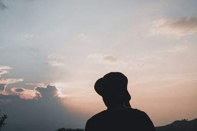 Silhouette man standing against sky during sunset