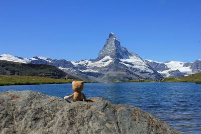 Lake in front of mountains against clear sky