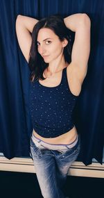 Portrait of beautiful young woman standing at home