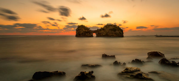 Scenic view of sea against romantic sky at sunset