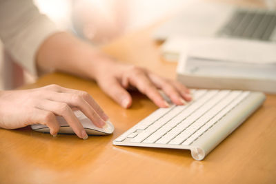 Close-up of woman using laptop on table