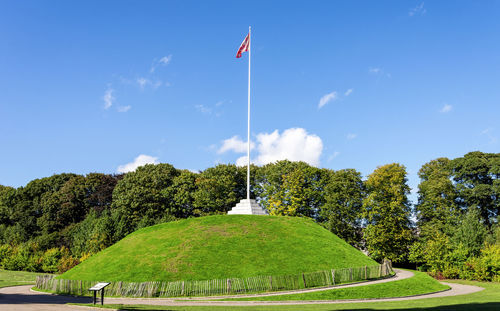 Scenic view of flag against sky in city