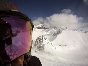 Person wearing helmet against snowcapped mountain